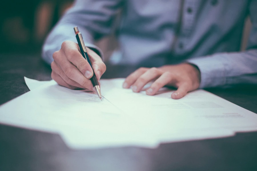 Une personne remplit des papiers administratiifs