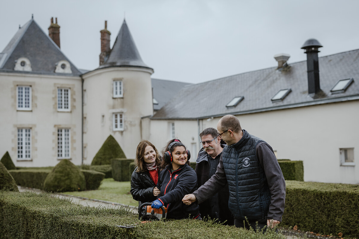Roumania Jaunet pose pour un portrait entourée de ses parents, Camille et Bruno Jaunet, et de son moniteur Nicolas Bonneau dans le domaine du château d'Auvilliers où Roumiana travaille à l'Esat, lundi 25 novembre 2024.