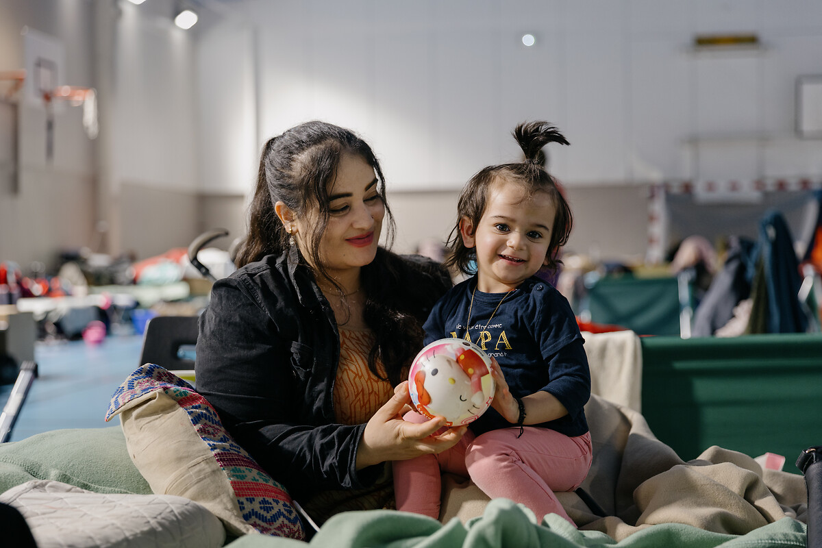 Une femme avec son enfant dans un gymnase de l'Armée du Salut